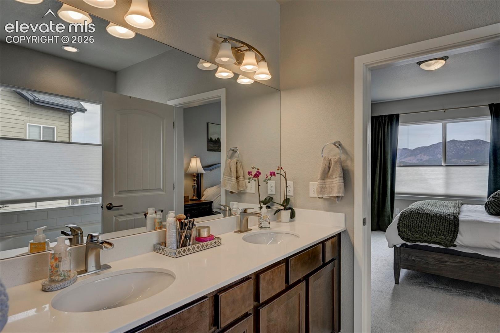 Double vanity with undermount sinks, chrome fixtures, and wood-finish cabinetry