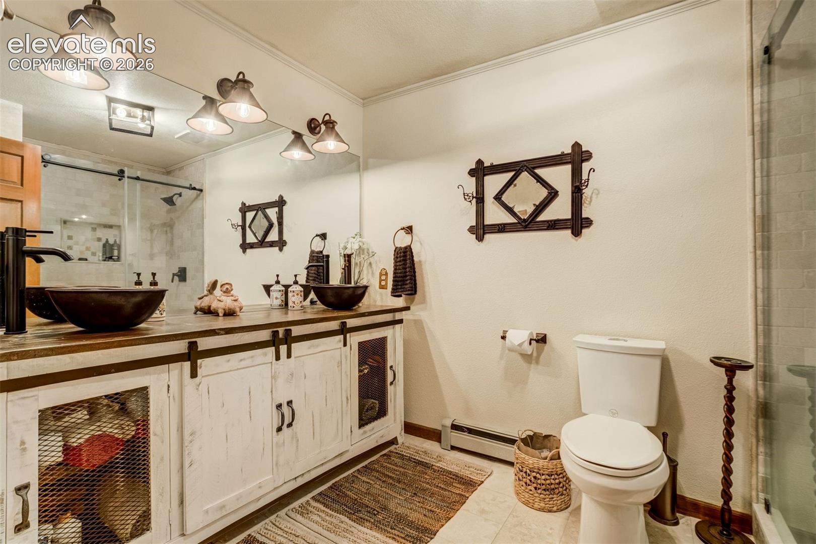 Custom basement bathroom with dual copper sinks and walk in shower. Custom travertine tile with accents not captured in photo