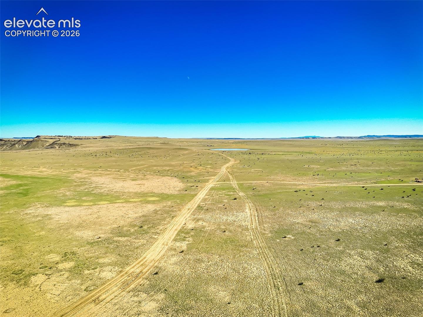 Expansive acreage featuring native terrain, a natural water pond, and dirt trails