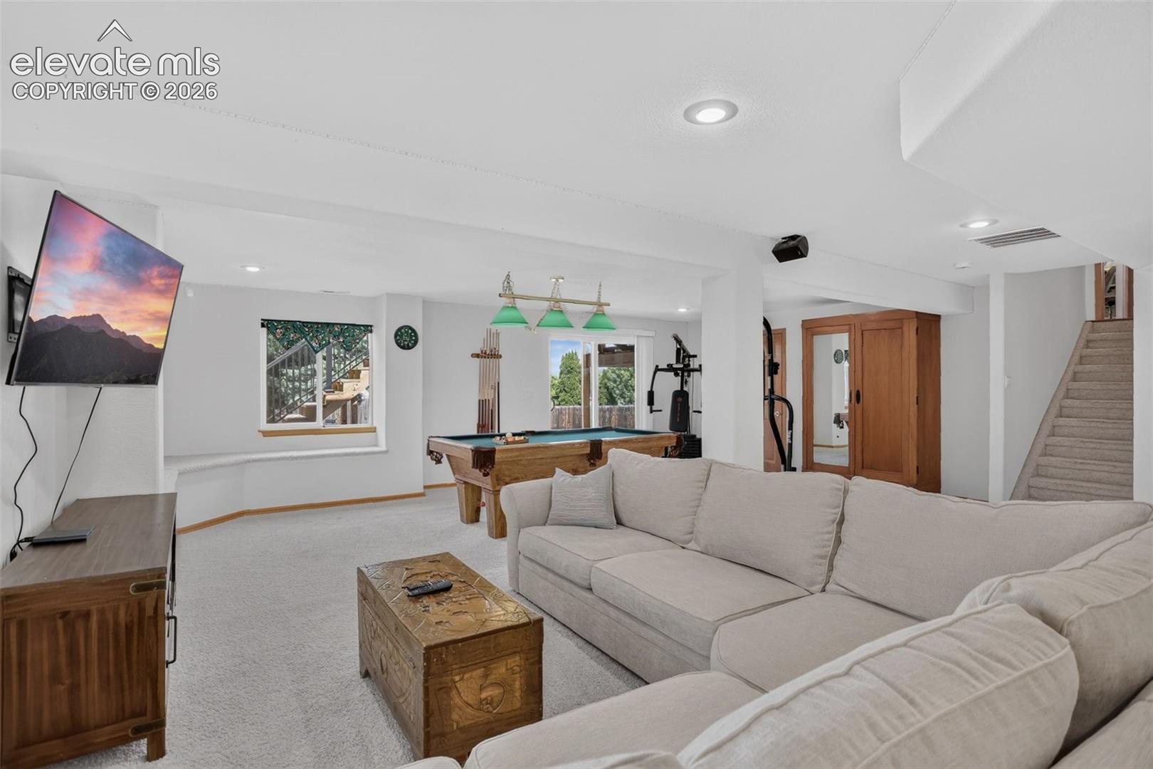 Spacious recreational area featuring carpet flooring, recessed lighting, and a pool table with overhead lighting