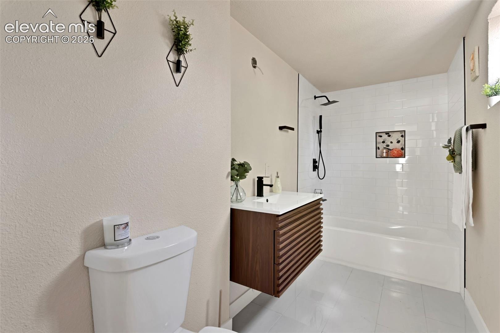 Modern bathroom featuring a floating wood-slat vanity with a white countertop and rectangular vessel sink