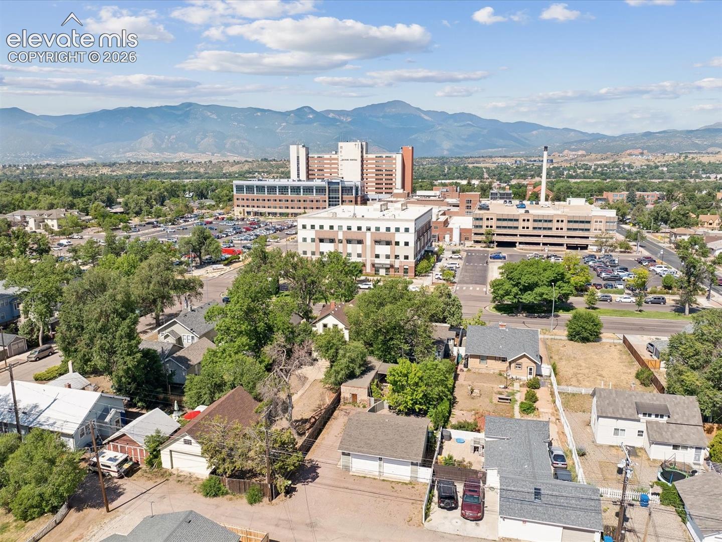 Aerial perspective showcasing a residential area with varied rooflines and mature trees