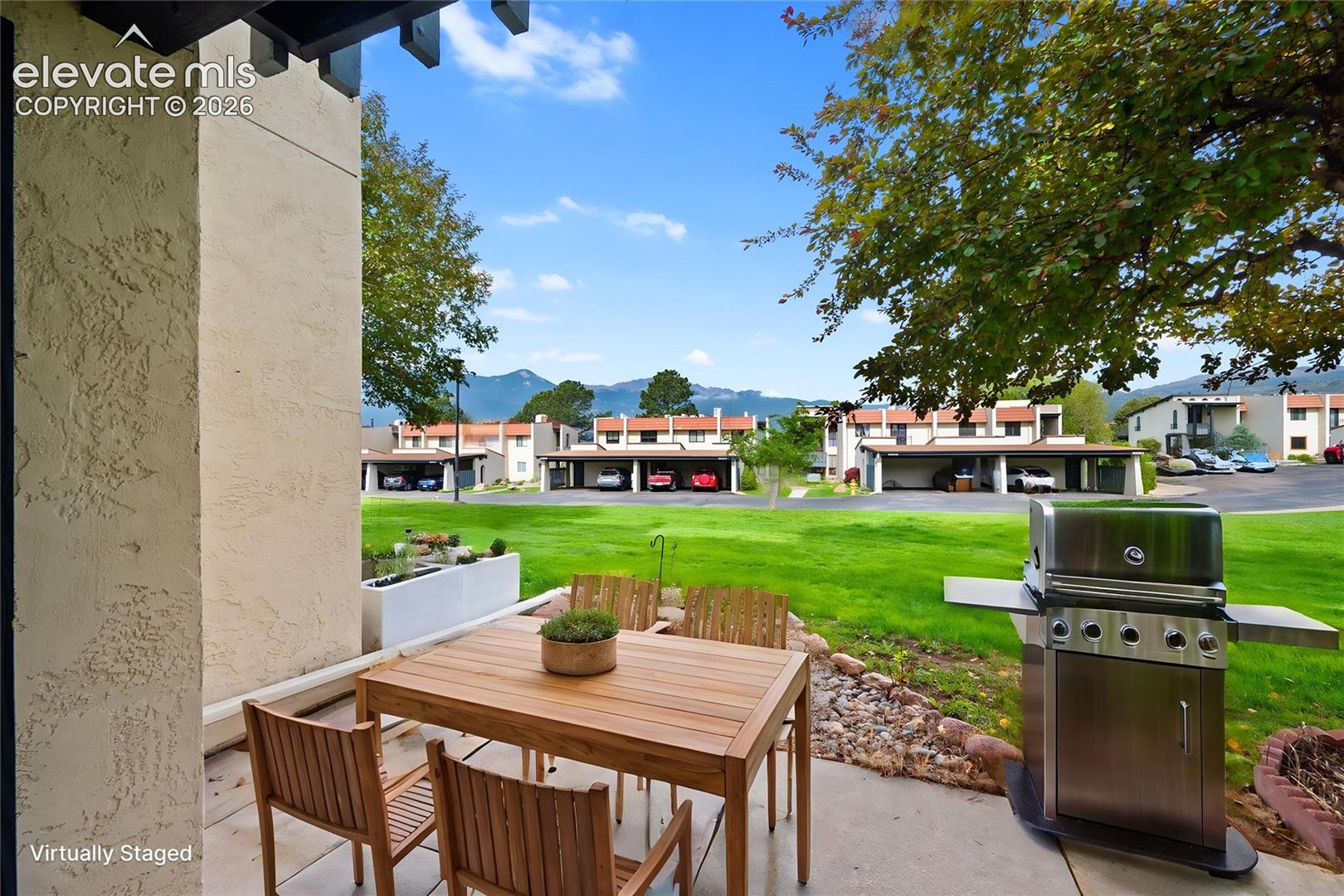 Covered patio featuring concrete flooring, a stucco structural column, and mountain scenery