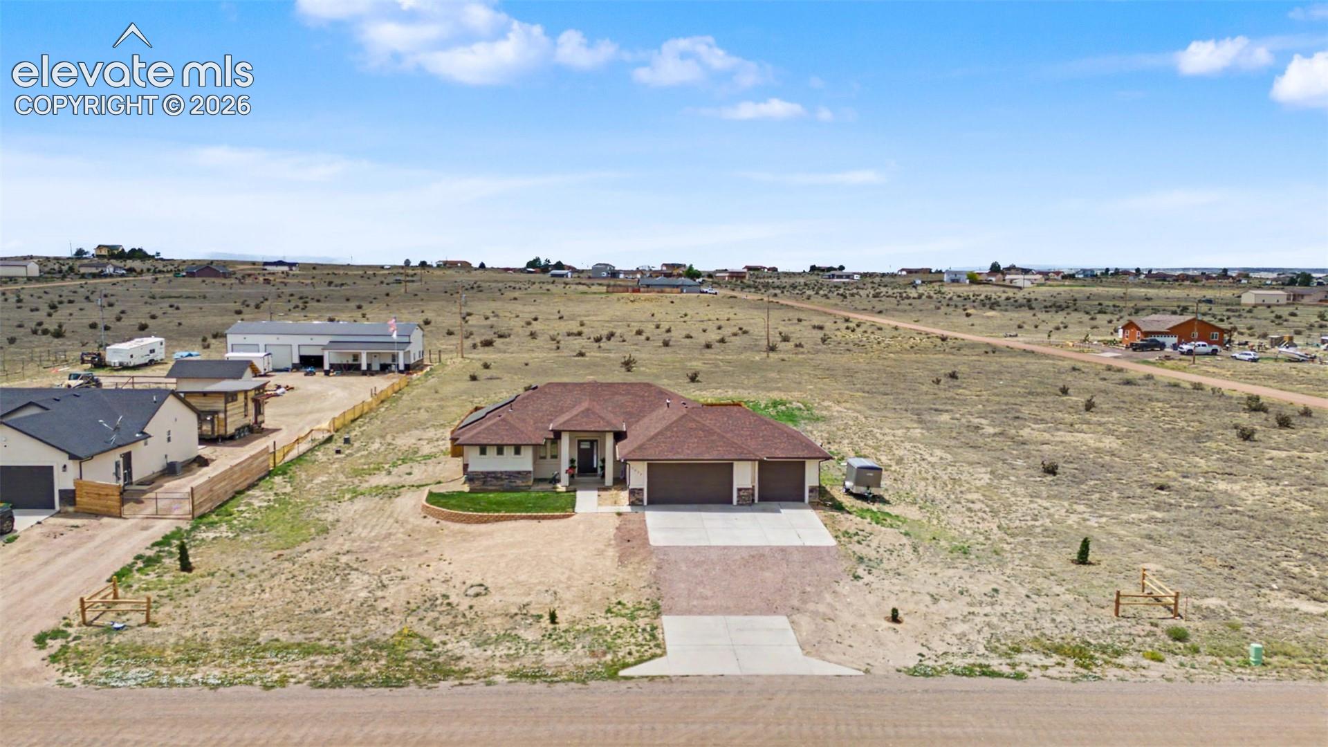 Single-story residence featuring a two-car garage, an additional single-car garage, and a brick paver driveway
