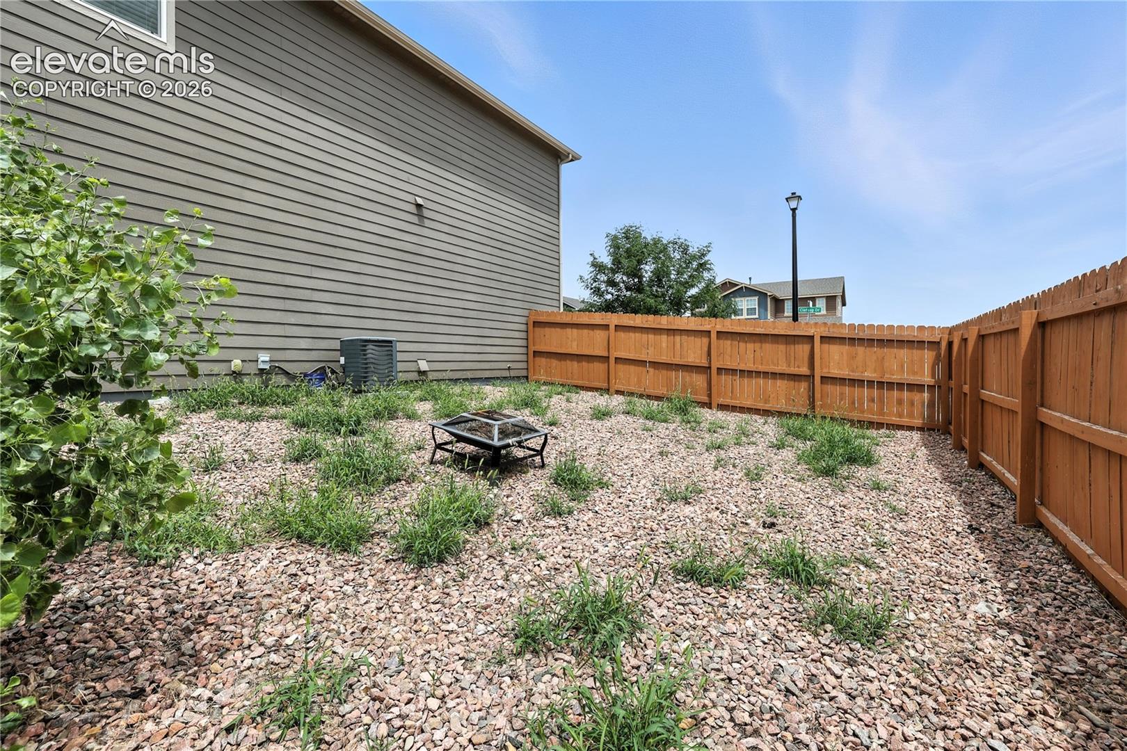 Fenced backyard featuring a gravel surface and privacy fencing