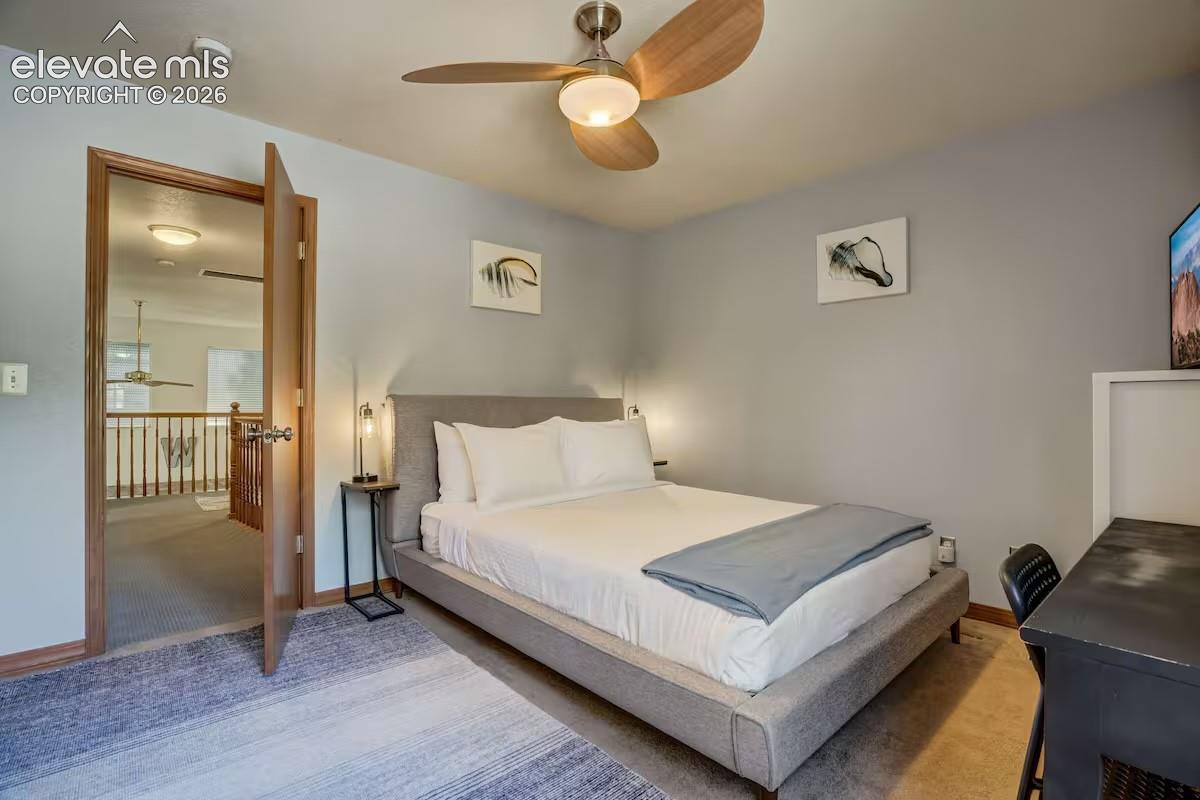 Bedroom featuring light gray walls, wood-finish door frames, a contemporary ceiling fan, and carpeted flooring