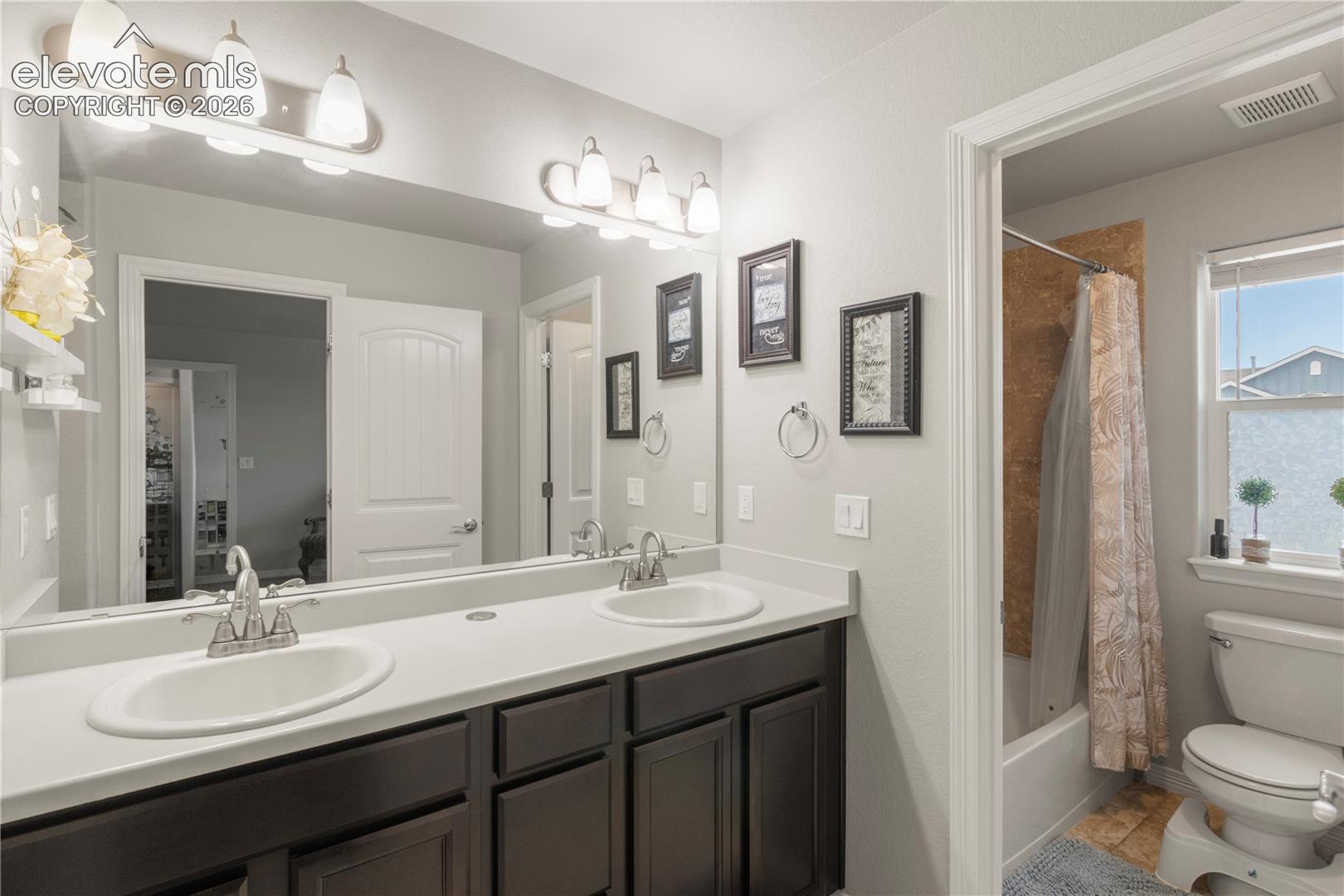 Dual vanity with integrated sinks and dark wood-finish cabinetry