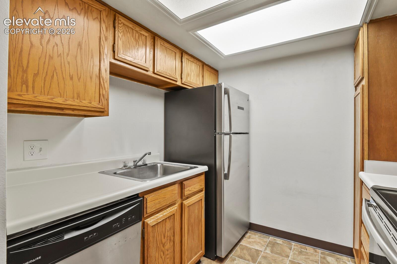 Kitchen featuring wood cabinetry, stainless steel sink, stainless steel appliances and recessed lighting and linoleum flooring