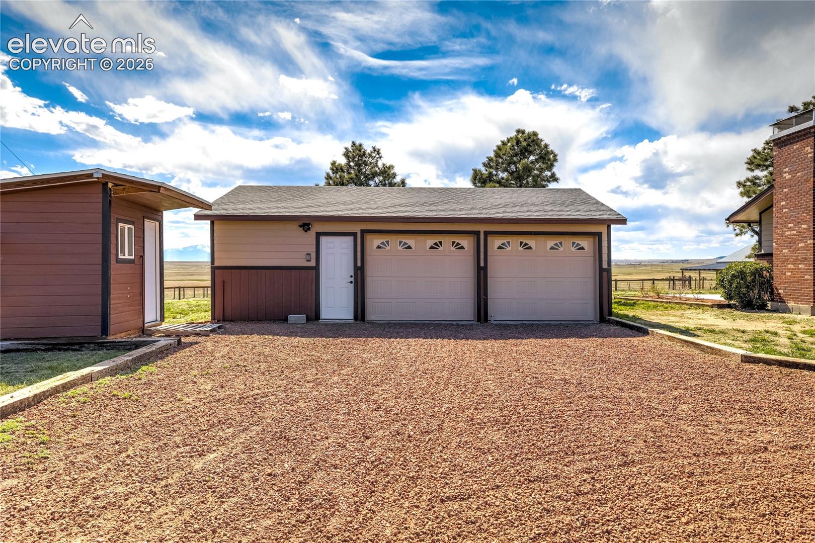 2 car garage with shop area, chicken coop to left. 