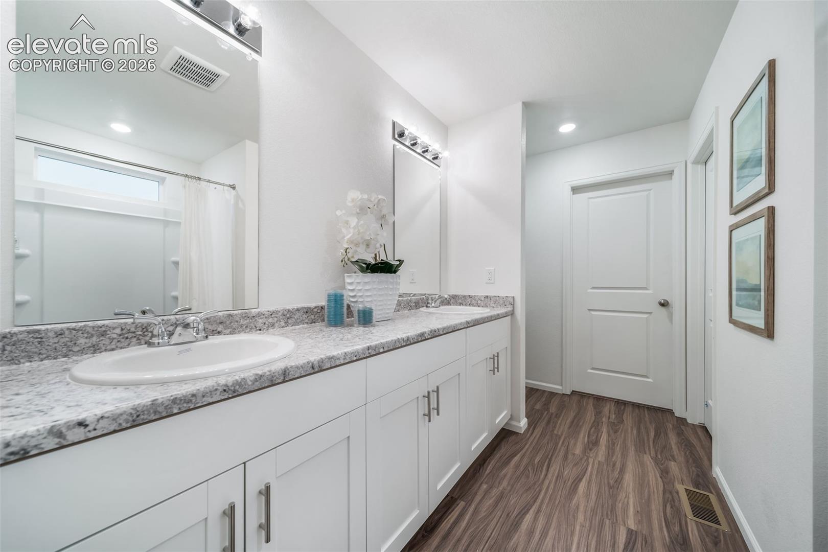 Double vanity with white cabinetry, light-toned countertops, and dual mirrors
*photos of a model home*