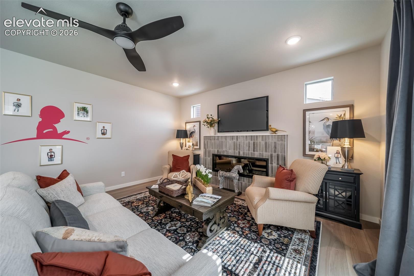 Living area featuring wood-finish flooring, a contemporary ceiling fan, and recessed lighting
*Photos of a model home*
