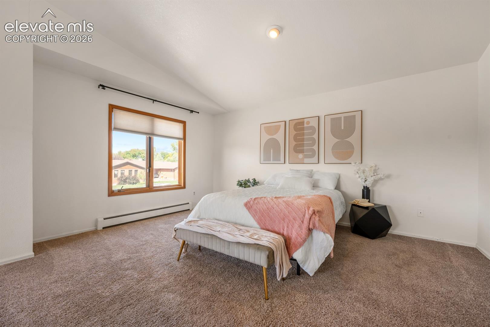 Vaulted ceiling, recessed lighting, warm wood-framed window, wall-to-wall carpeting, and baseboard heating