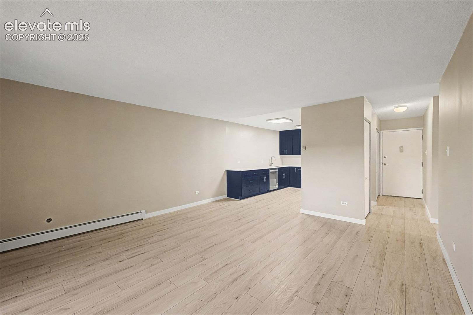 Expansive living area featuring light wood-finish flooring, neutral wall tones, and recessed lighting