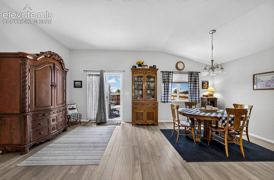 Vaulted ceilings accentuate the spacious interior, featuring wood-finish flooring throughout