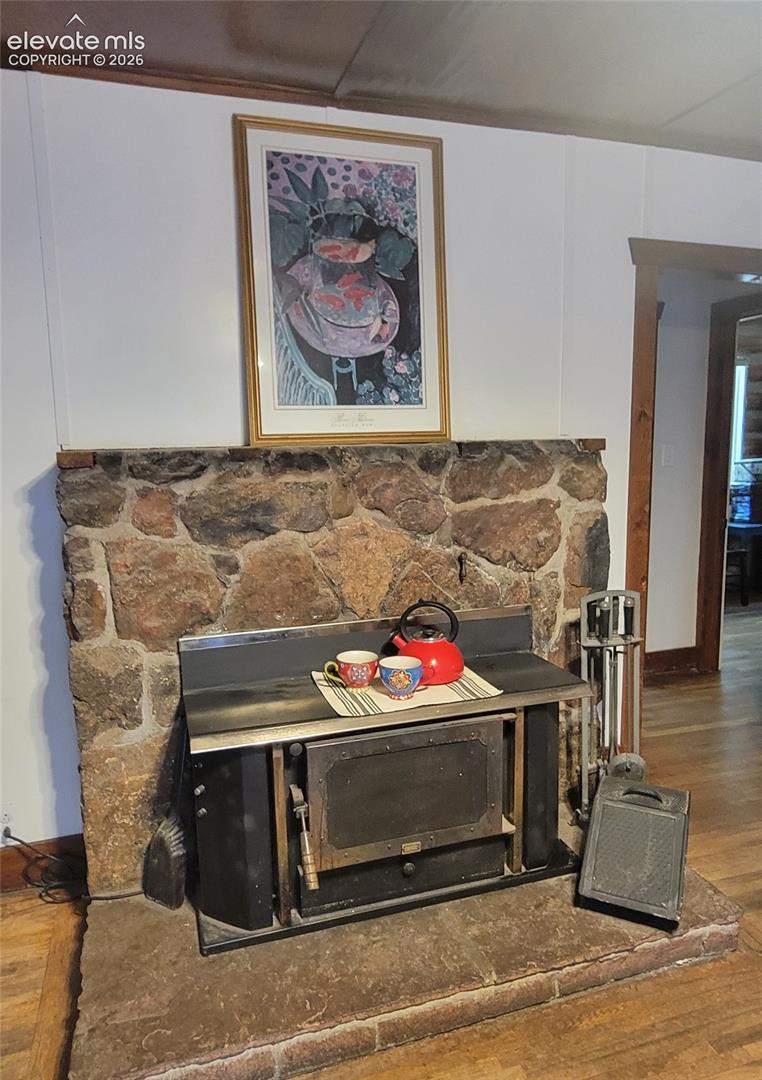 Stone-faced fireplace with a wood-burning insert and an extended hearth