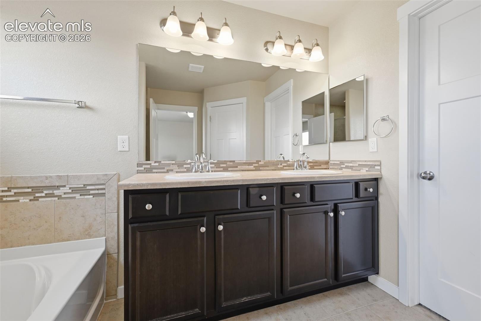 The private primary bath offers an extended dual-sink vanity with plenty of storage.