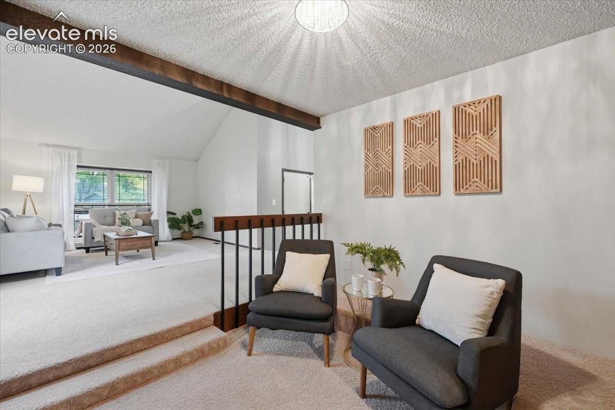 Vaulted ceiling, exposed ceiling beam, and wood-finish railing