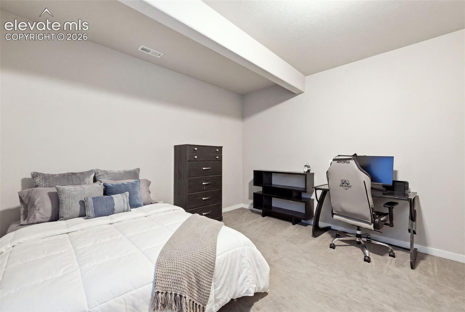 Neutral wall color with recessed lighting, complemented by a textured ceiling and light-toned carpeting.