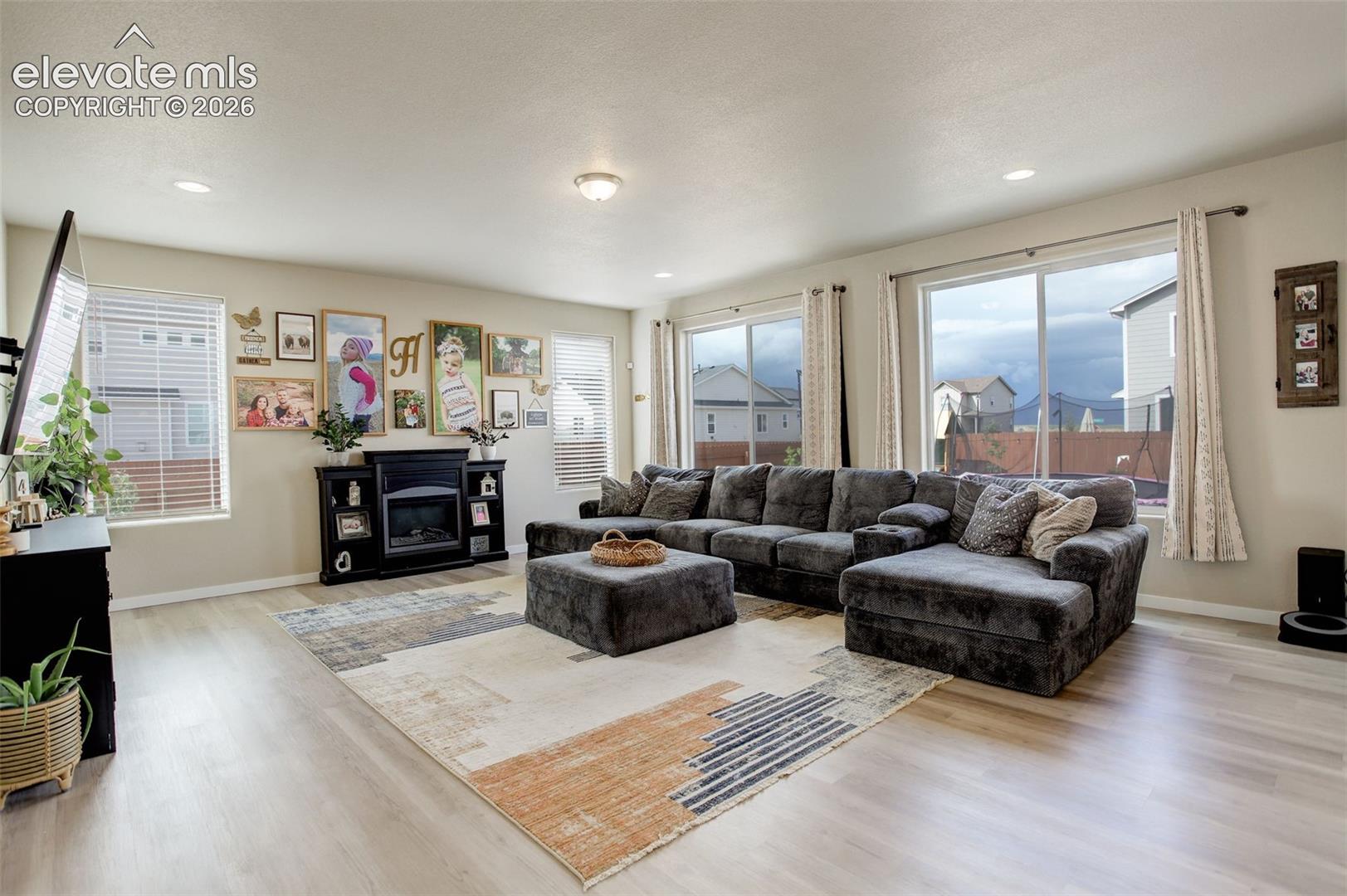 Main level; Living area featuring wood finished floors, a glass covered fireplace, and recessed lighting