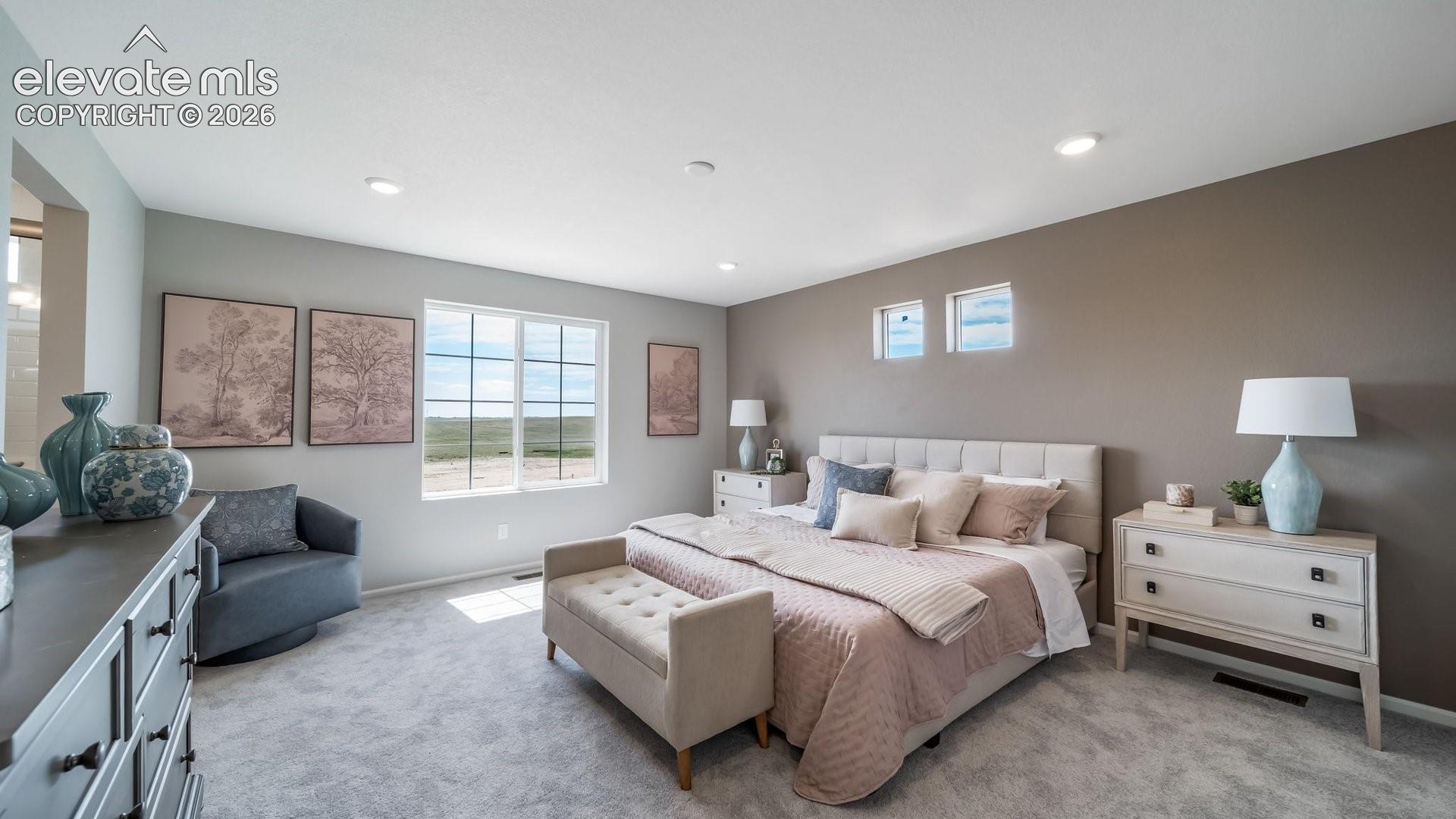 Recessed lighting illuminates a spacious room featuring wall-to-wall carpeting and a large multi-pane window
*photos of a model home*