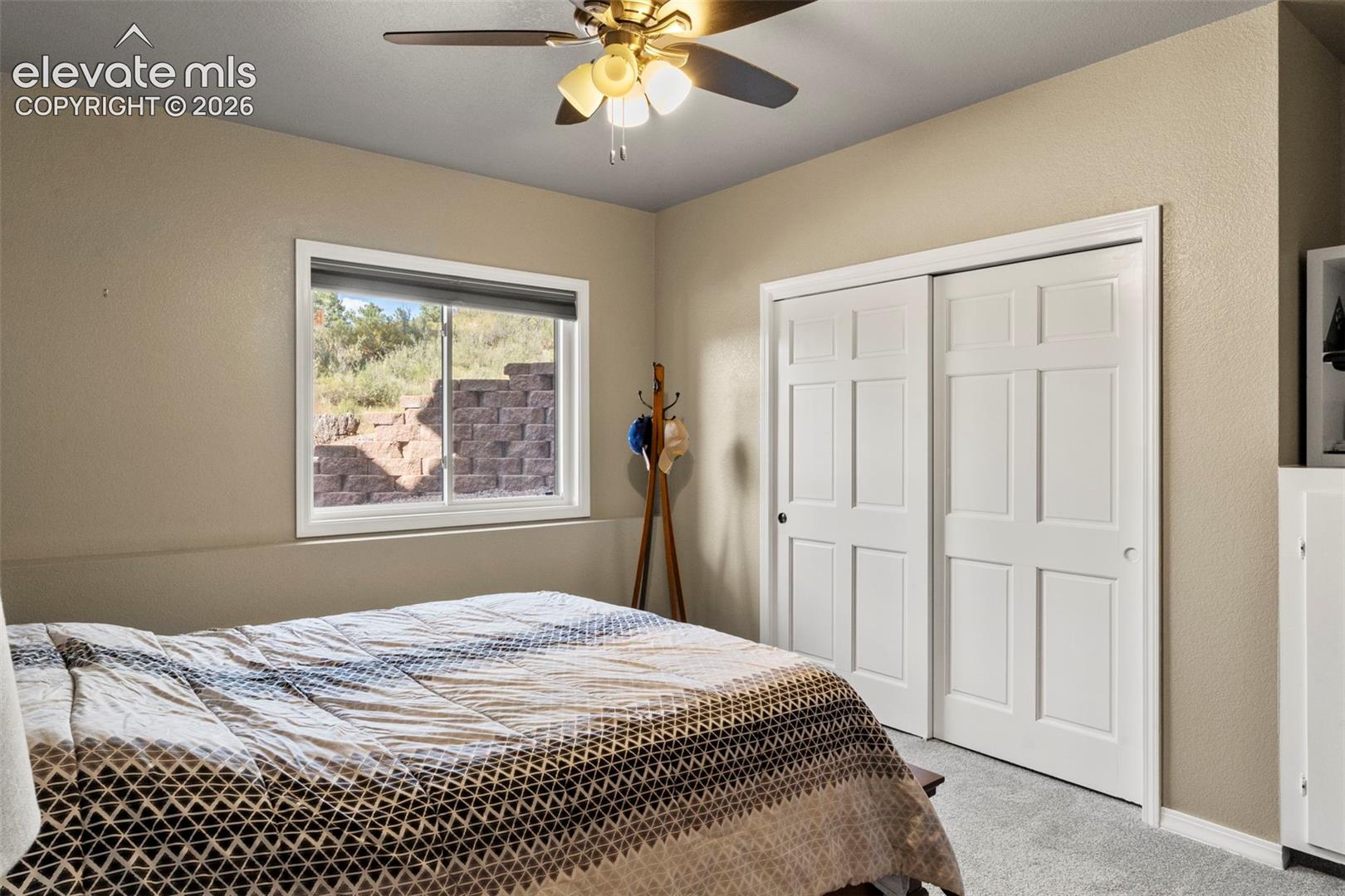 Bedroom with carpet, a closet, and ceiling fan