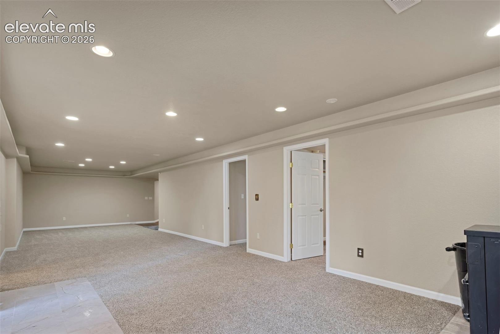 Basement open area with doors to bedrooms