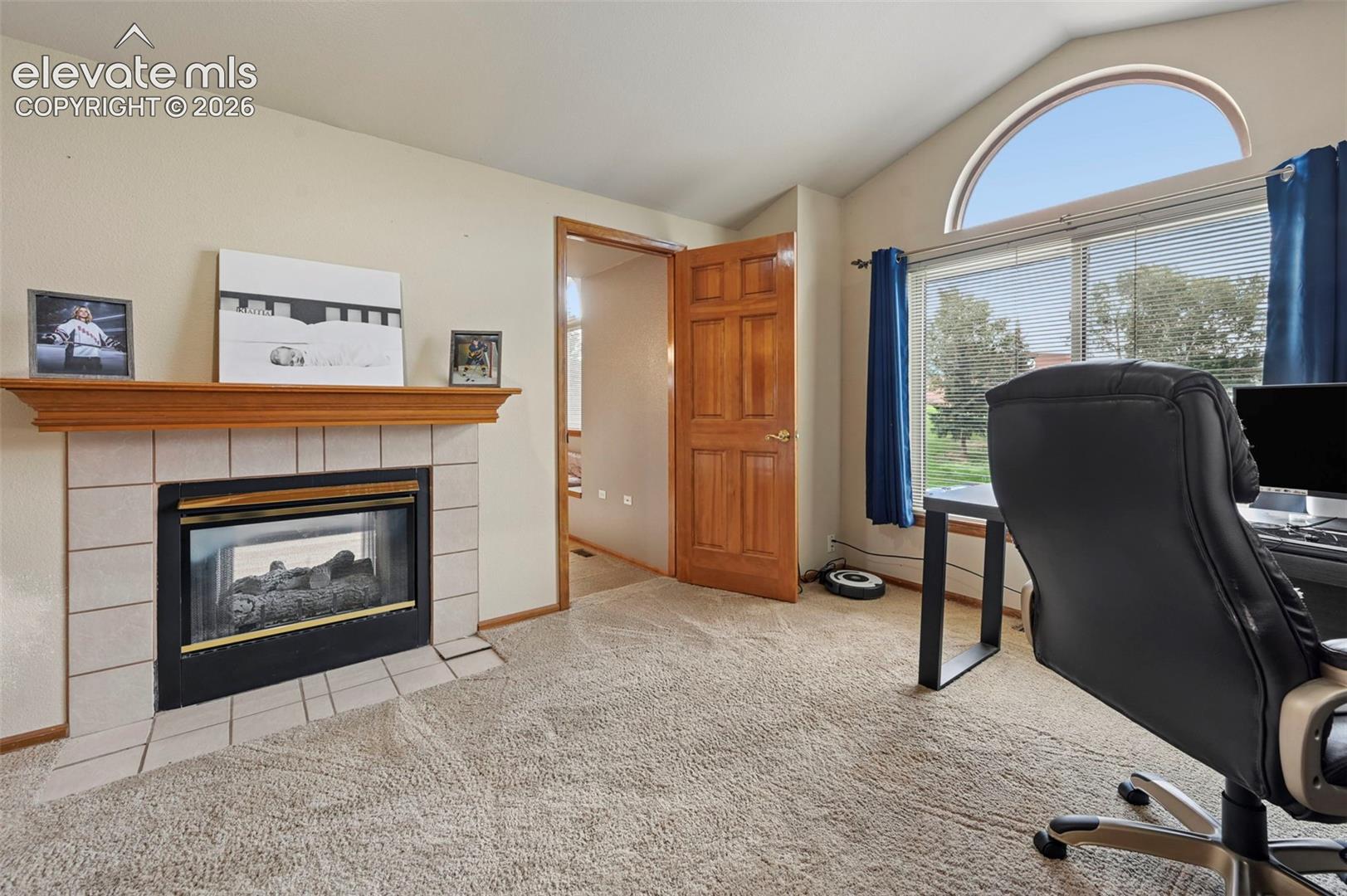 Fireplace with a tile surround and wood mantel