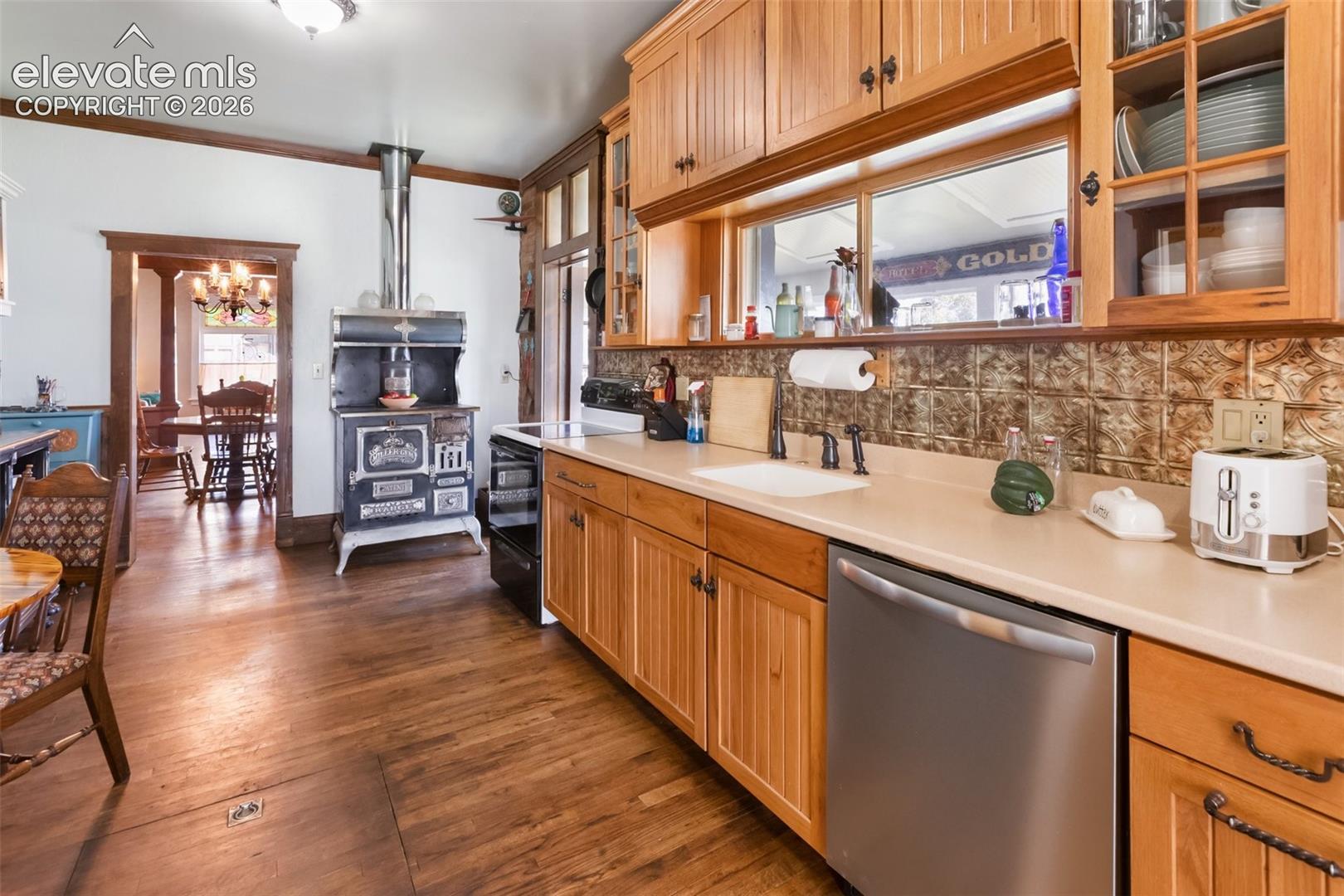 lots of hard surface counter space, lots of high quality wood cabinets providing lot of storage, built in dishwasher, note entry into the Solarium to the right of the coal and wood stove