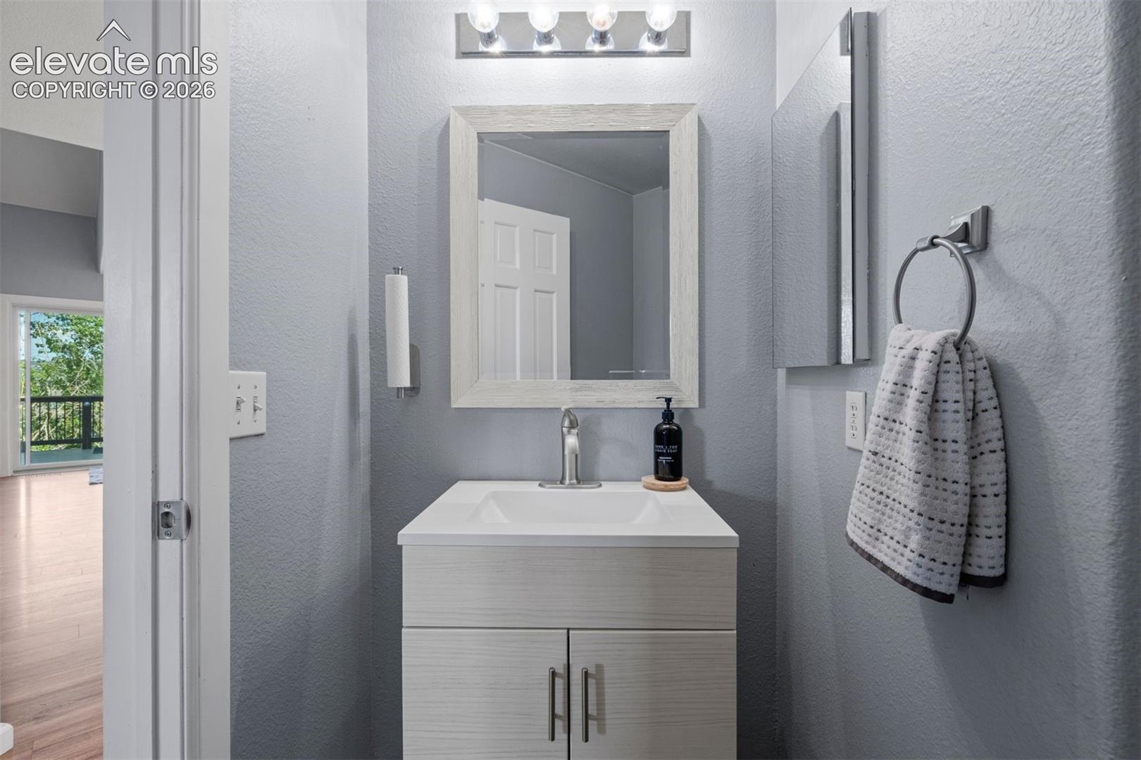 Bathroom vanity featuring a white rectangular sink, chrome faucet, and integrated storage cabinet