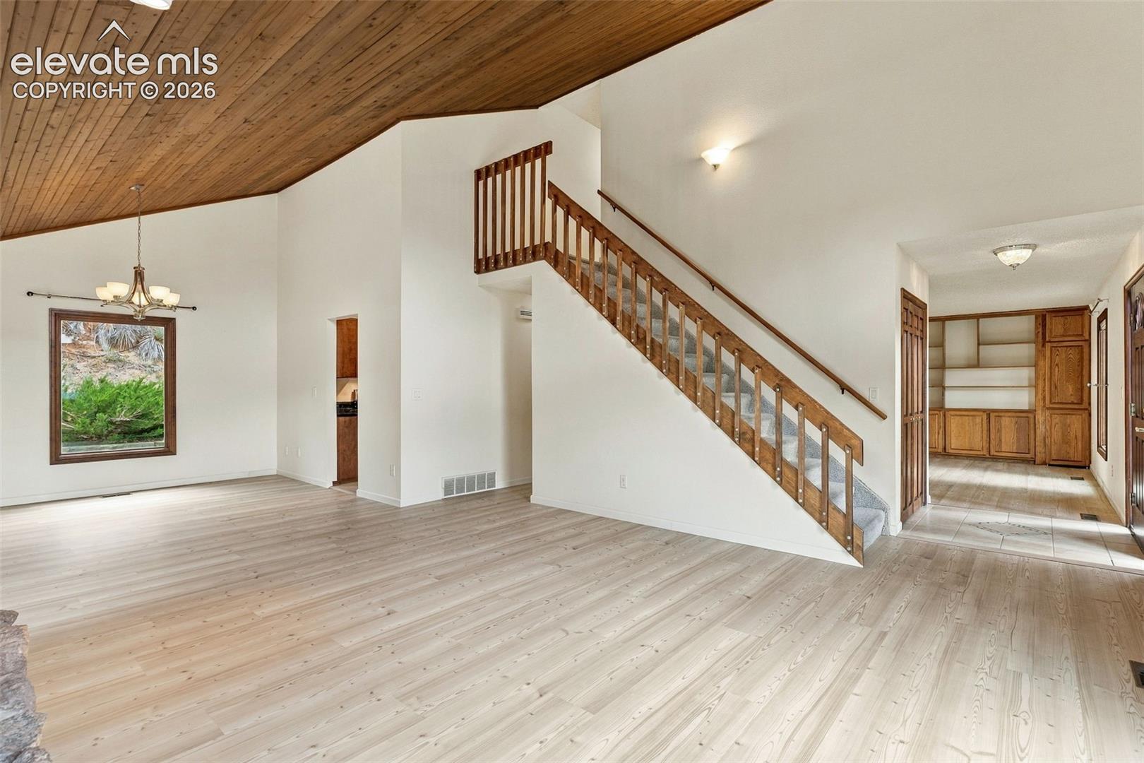 Living and formal dining areas have vaulted ceilings.