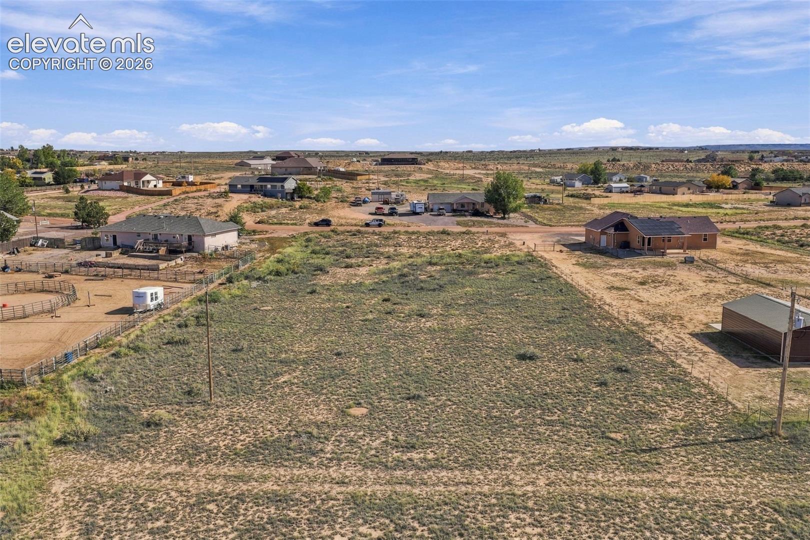 Expansive vacant lot featuring native high-desert terrain, open space, and perimeter fencing