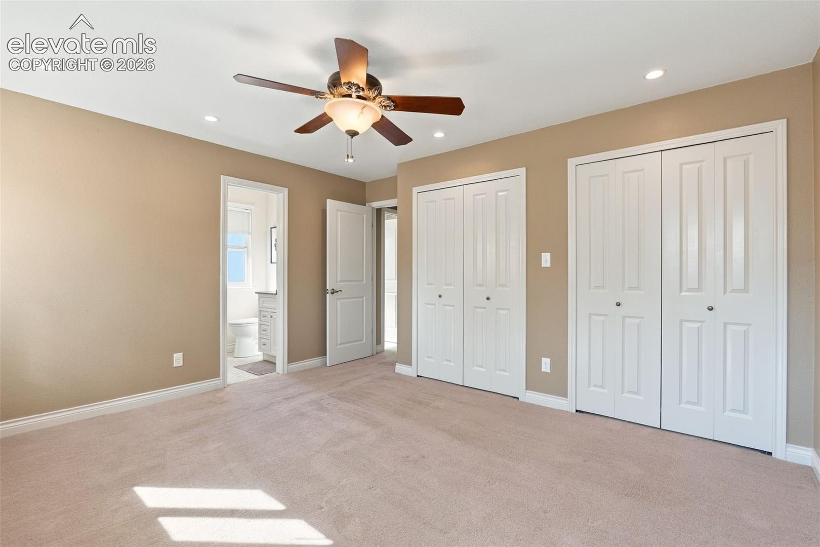 Interior room featuring neutral carpeting, a ceiling fan with integrated lighting, recessed lighting, and double-door closets