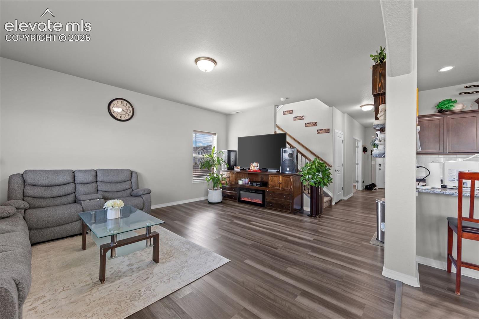 Open-concept living space featuring wood-finish flooring, recessed lighting, and a neutral color palette