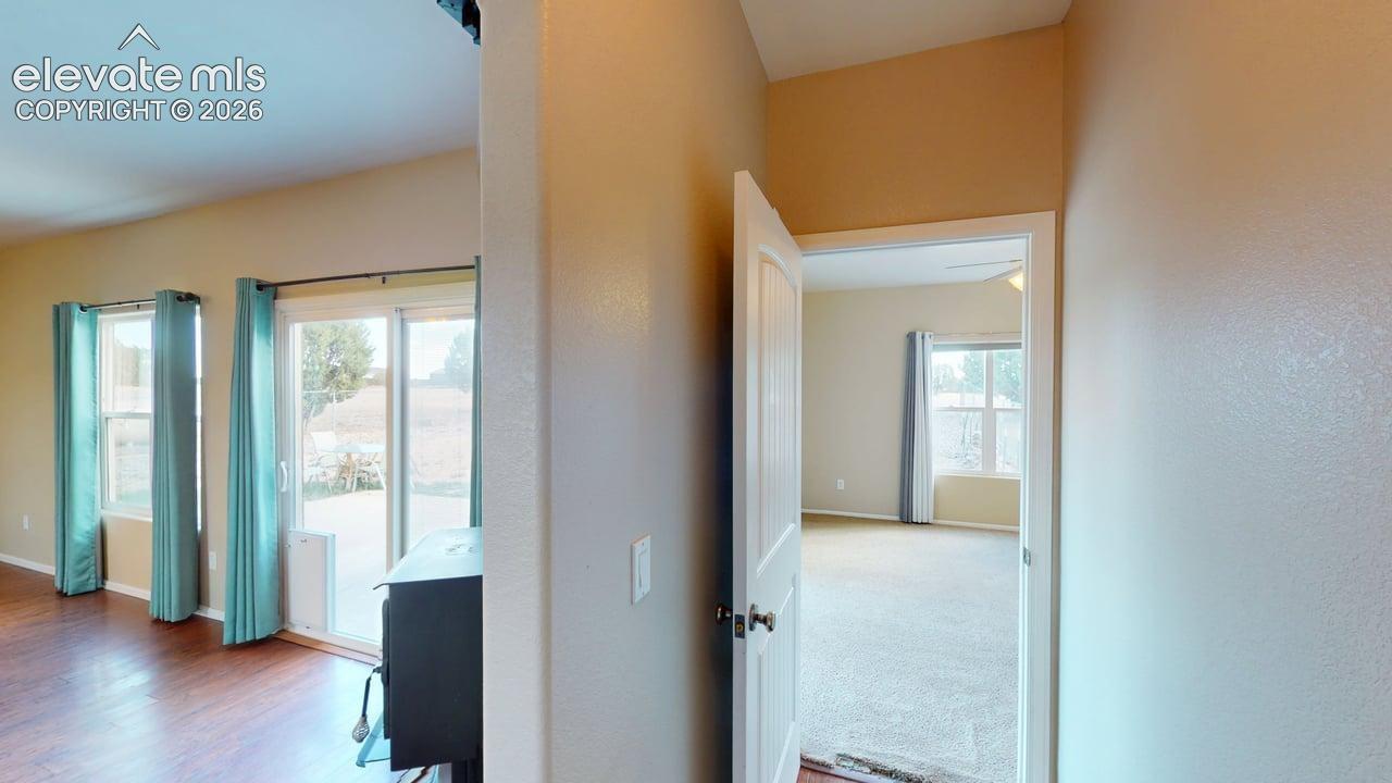 Wood-finish flooring, sliding glass door, built-in fireplace, and vaulted ceiling