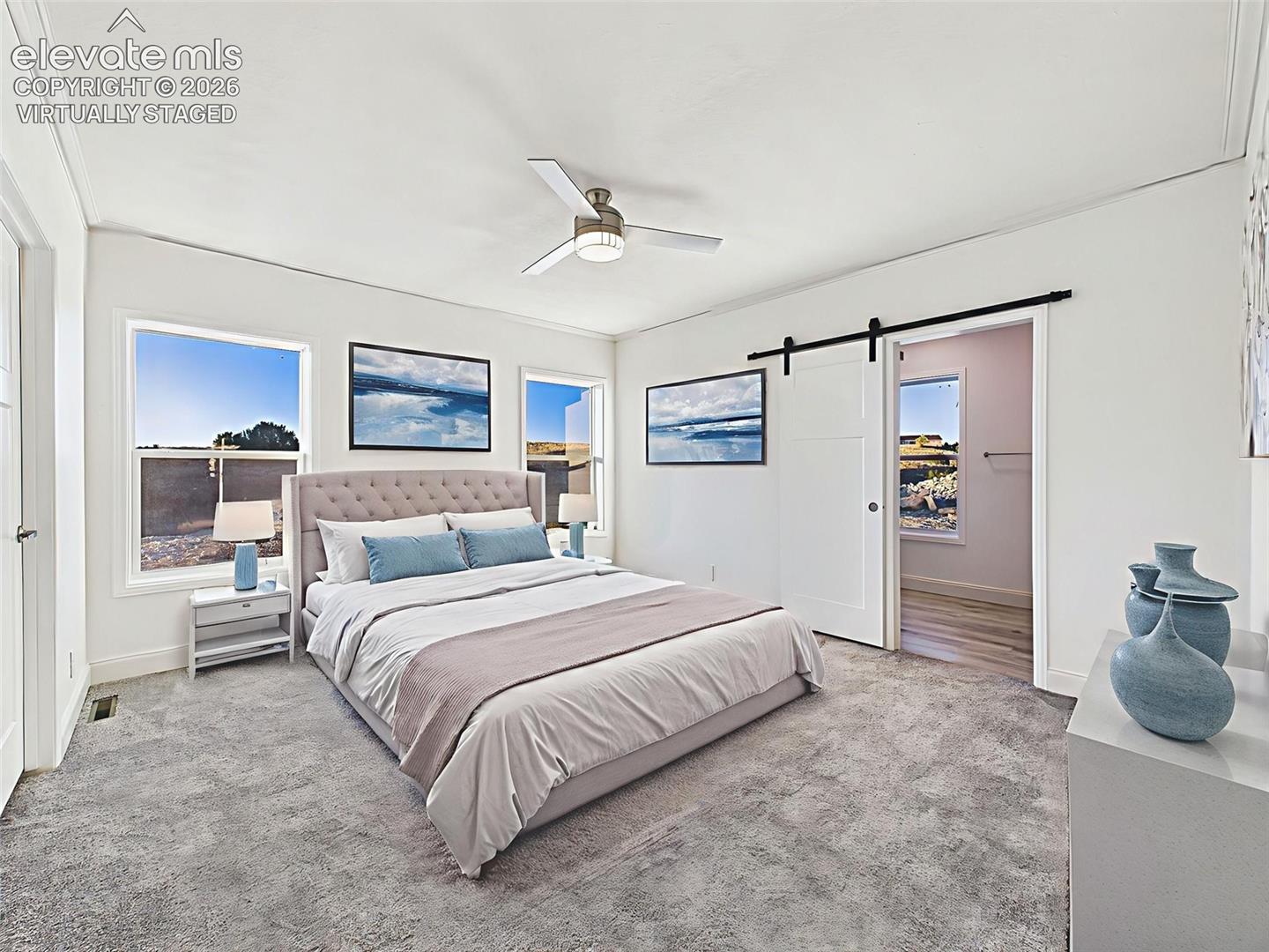Virtually Staged Spacious primary suite with bright natural light, plush carpeting, and barn door access to ensuite bath.