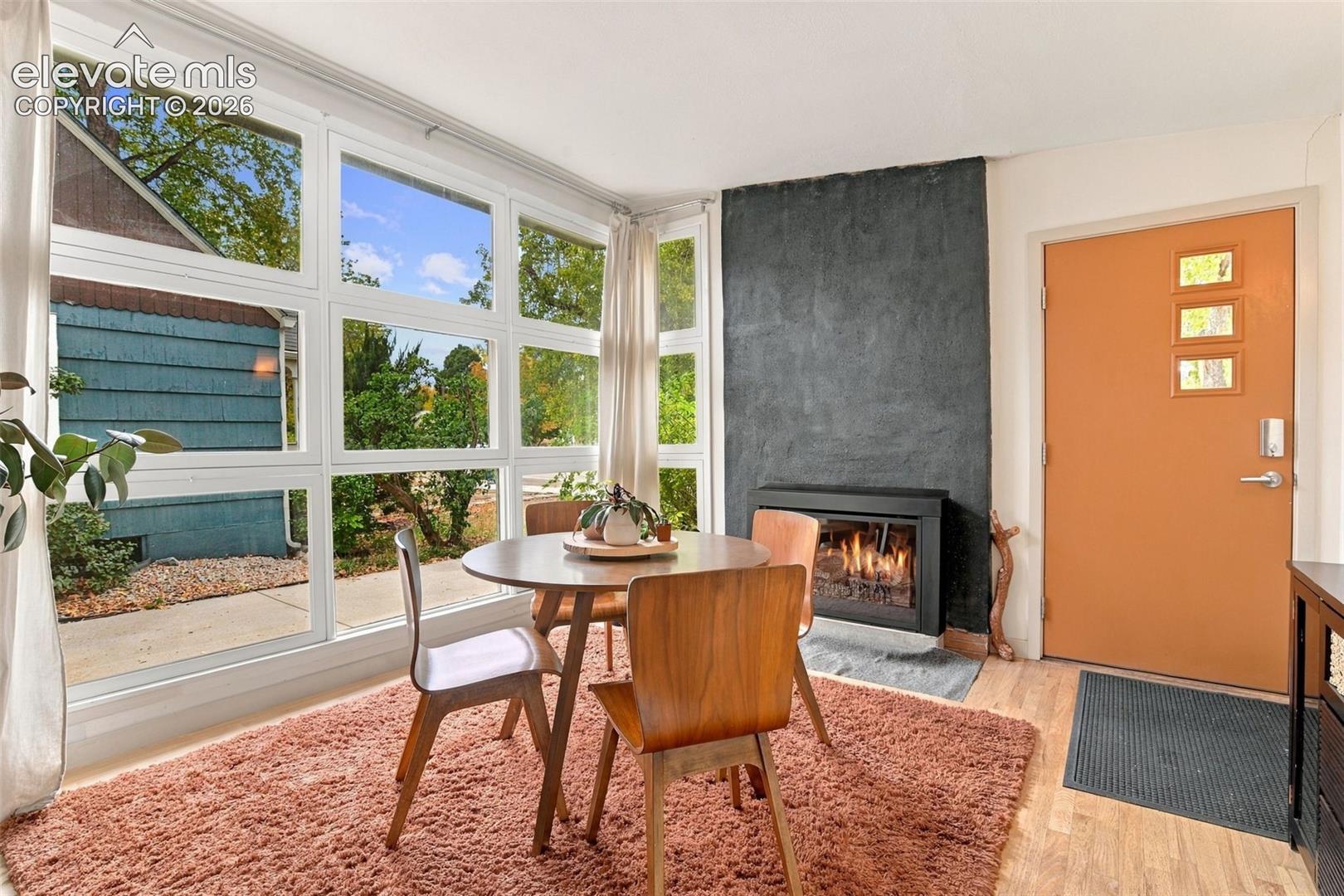 Floor-to-ceiling multi-pane windows, textured floor-to-ceiling fireplace surround, and built-in modern gas fireplace insert