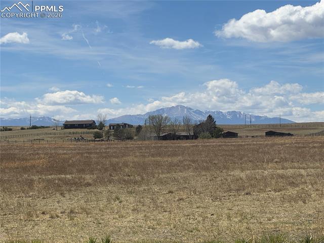 The property features expansive fields of dry grass and offers distant mountain views