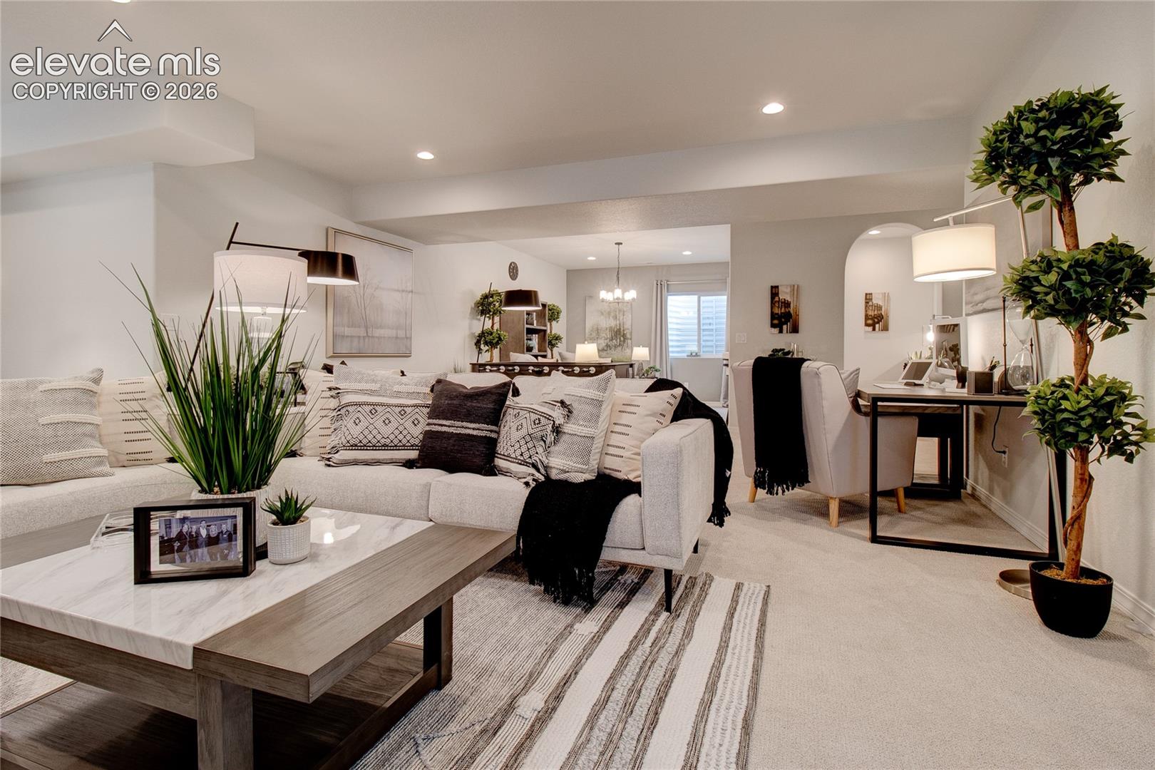 Open floor plan featuring recessed lighting, neutral wall tones, arched wall detailing, and wall-to-wall carpeting