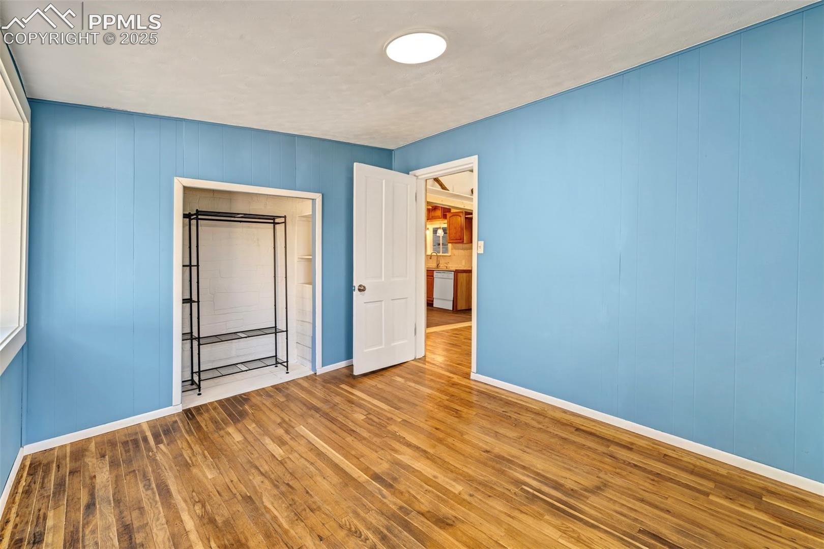 Blue Bedroom with updated fixtures, fresh paint, and natural hardwood floors