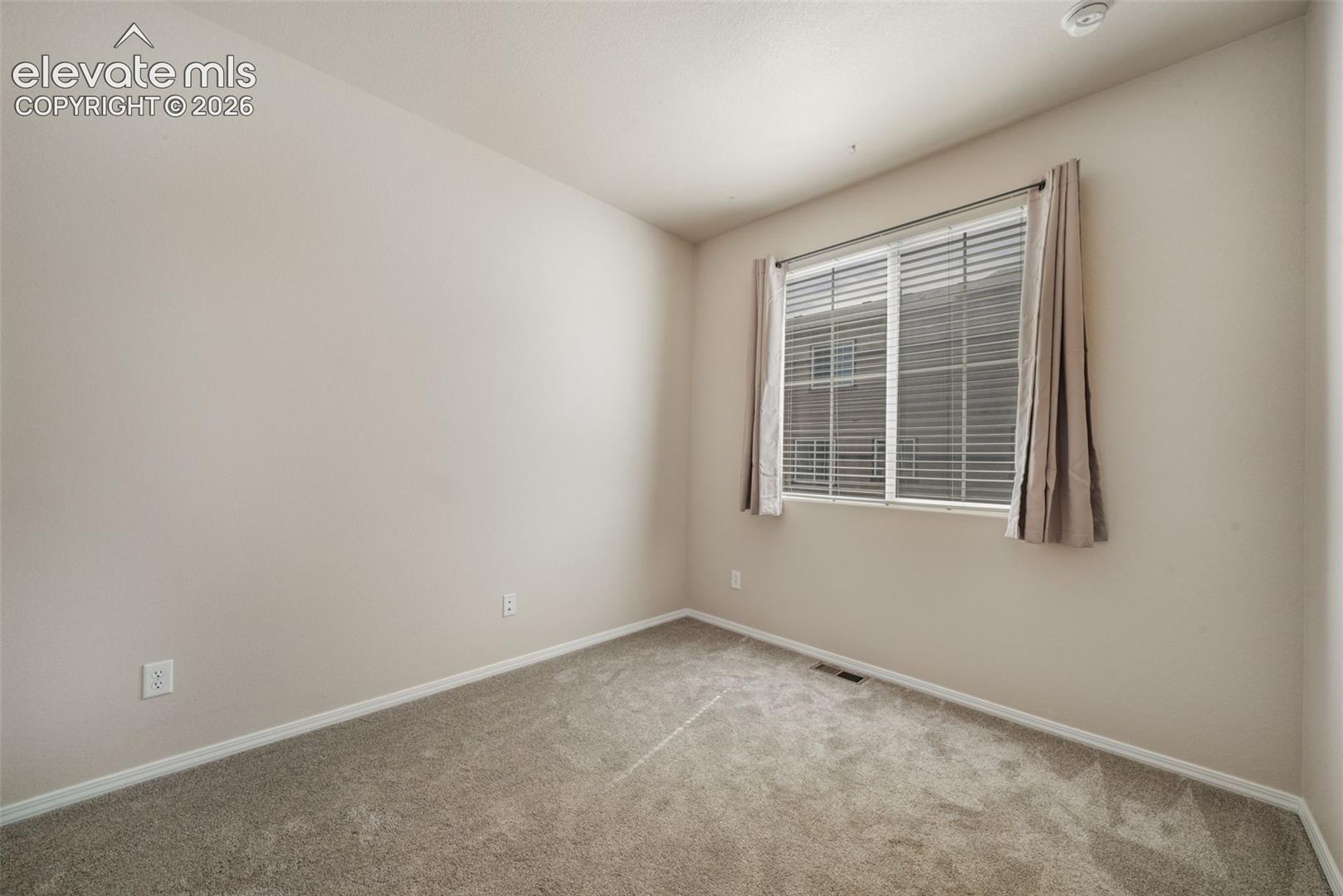 Carpeted flooring, neutral wall tones, and a window with blinds