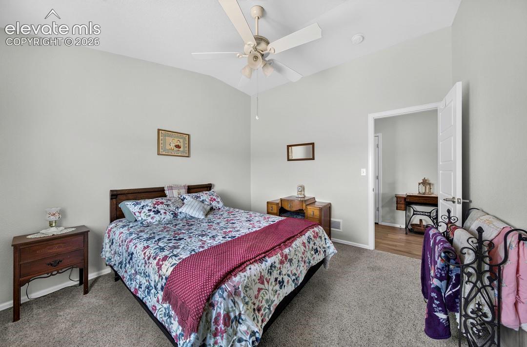 Vaulted ceiling with neutral wall tones and textured carpeting
