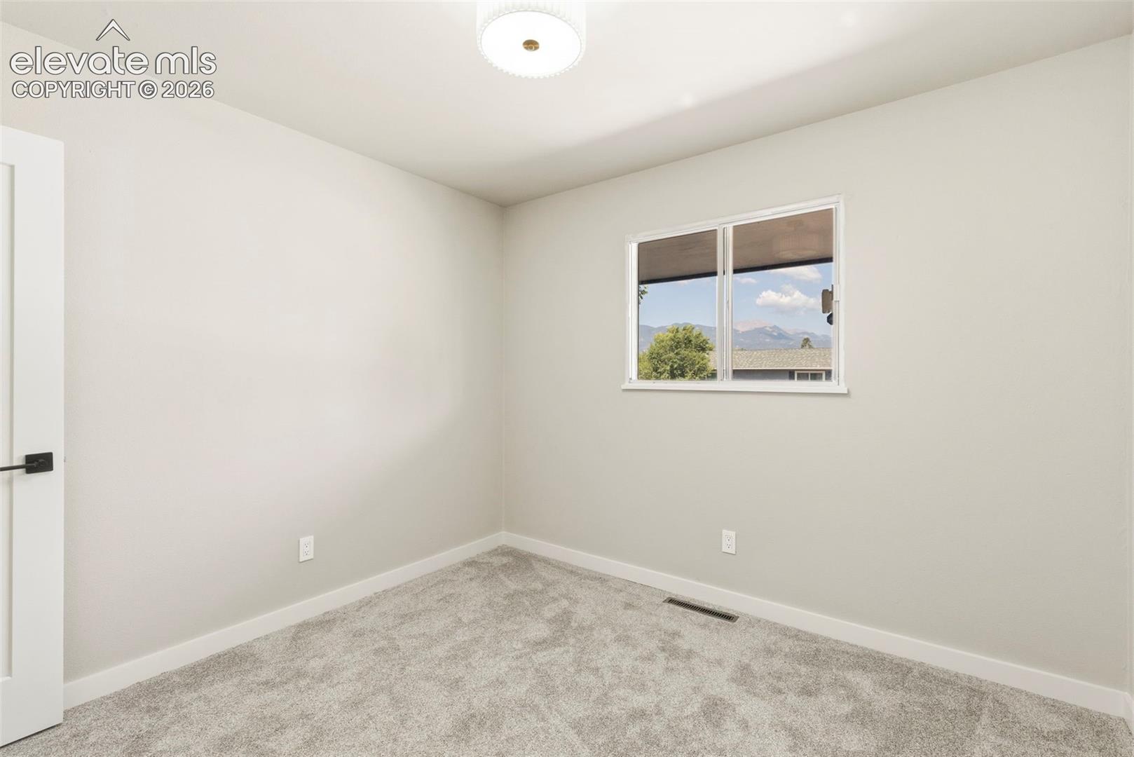 Room featuring light taupe carpet, white baseboards, and neutral wall paint