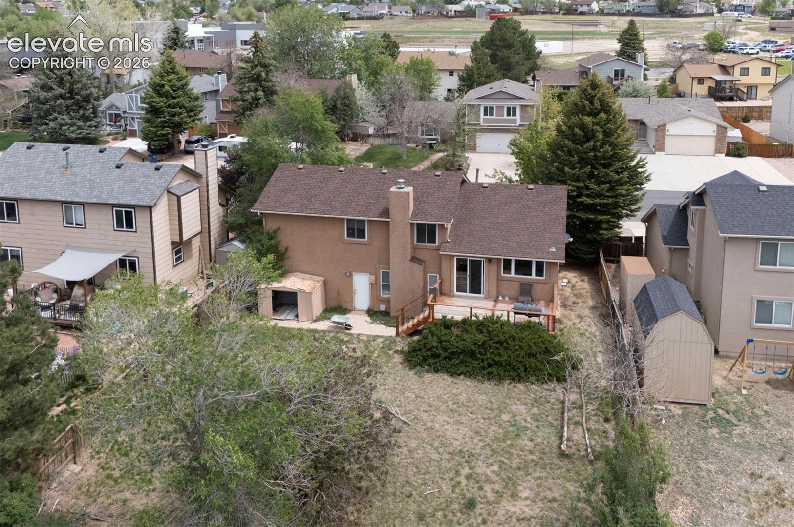 Rear exterior with a wood deck, sliding glass door access, and a stucco finish