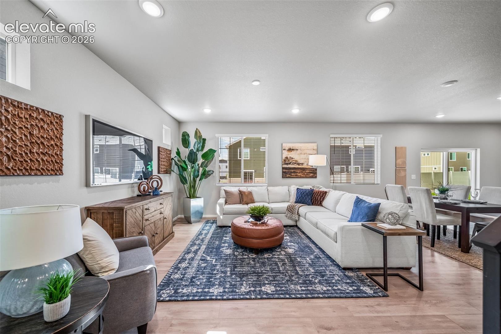 Recessed lighting illuminates the open-concept living space, featuring wood-finish flooring and multiple windows
*photos of a model home*