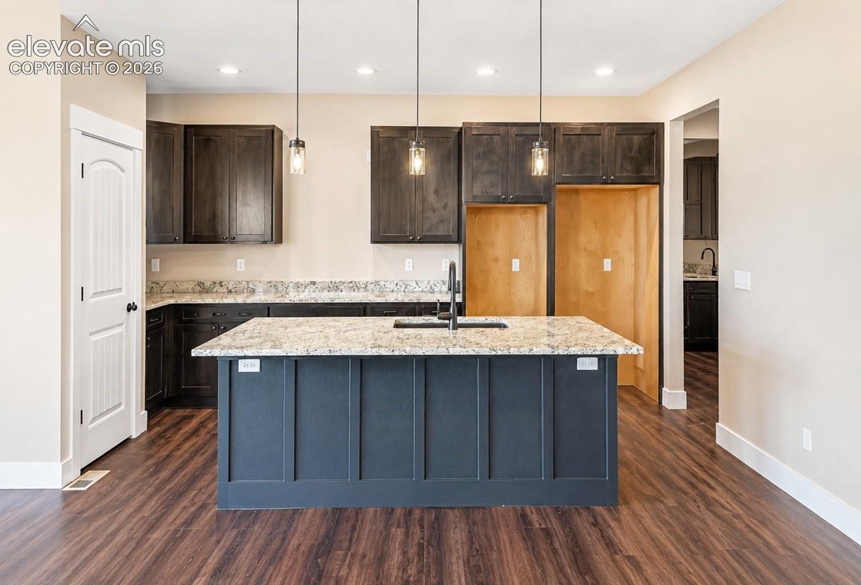 Central kitchen island with a light-toned countertop and dark paneling