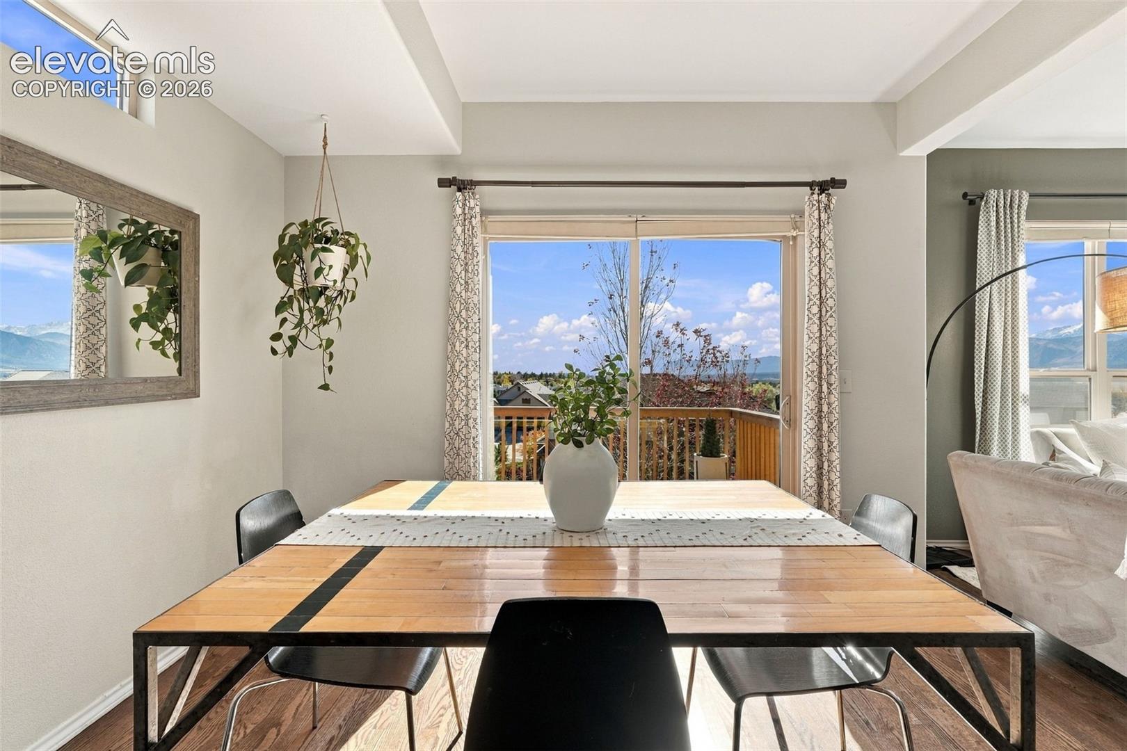 Open-concept living space featuring high ceilings, transom windows, wood-finish flooring, and sliding glass doors with access to an exterior deck