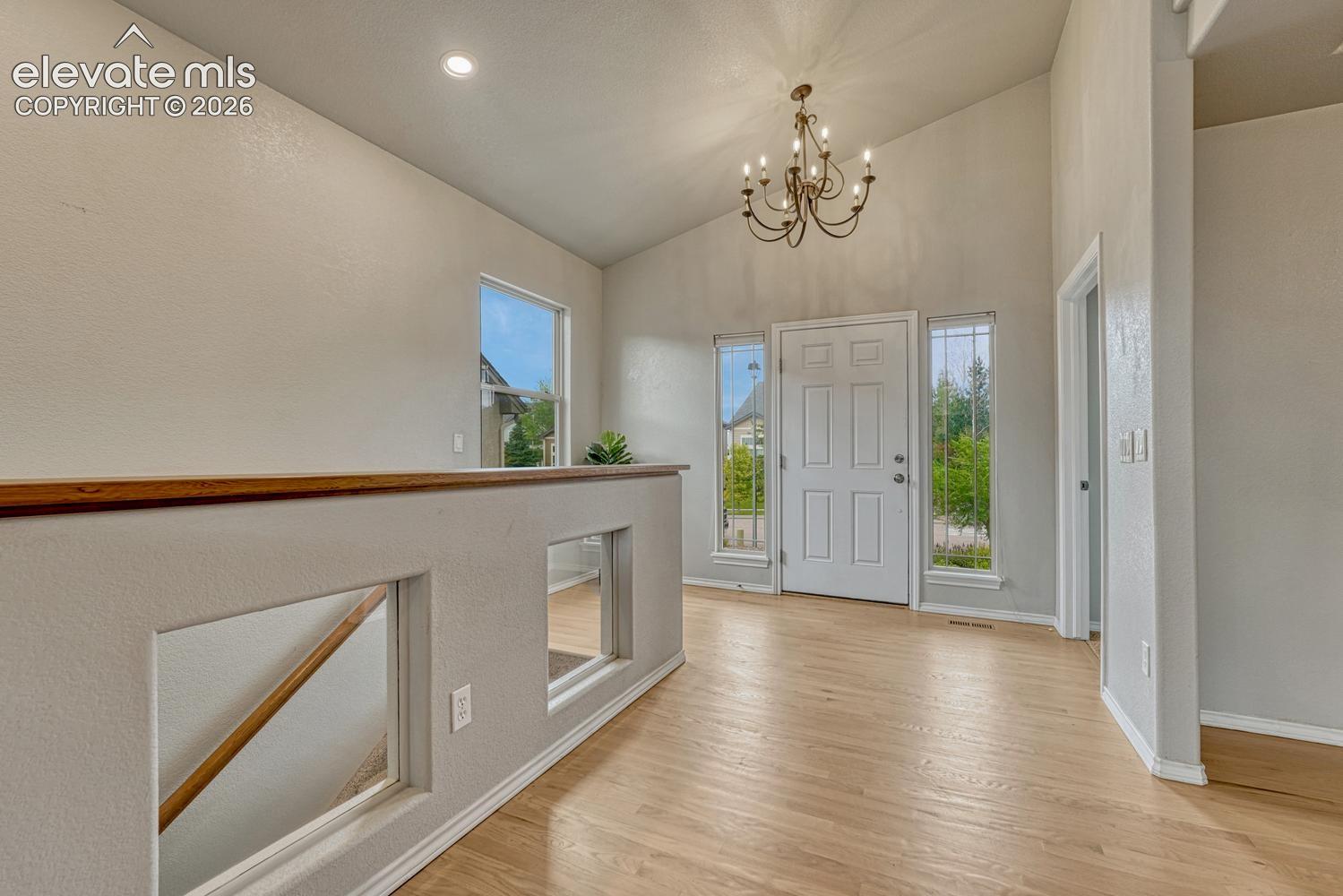 Welcoming Front Entry with wood flooring, side lite windows and an attractive light fixture.
