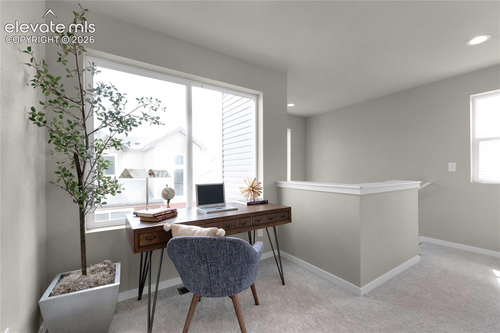 Large window, recessed lighting, carpeted flooring, and a built-in half-wall
*photos of a model home*
