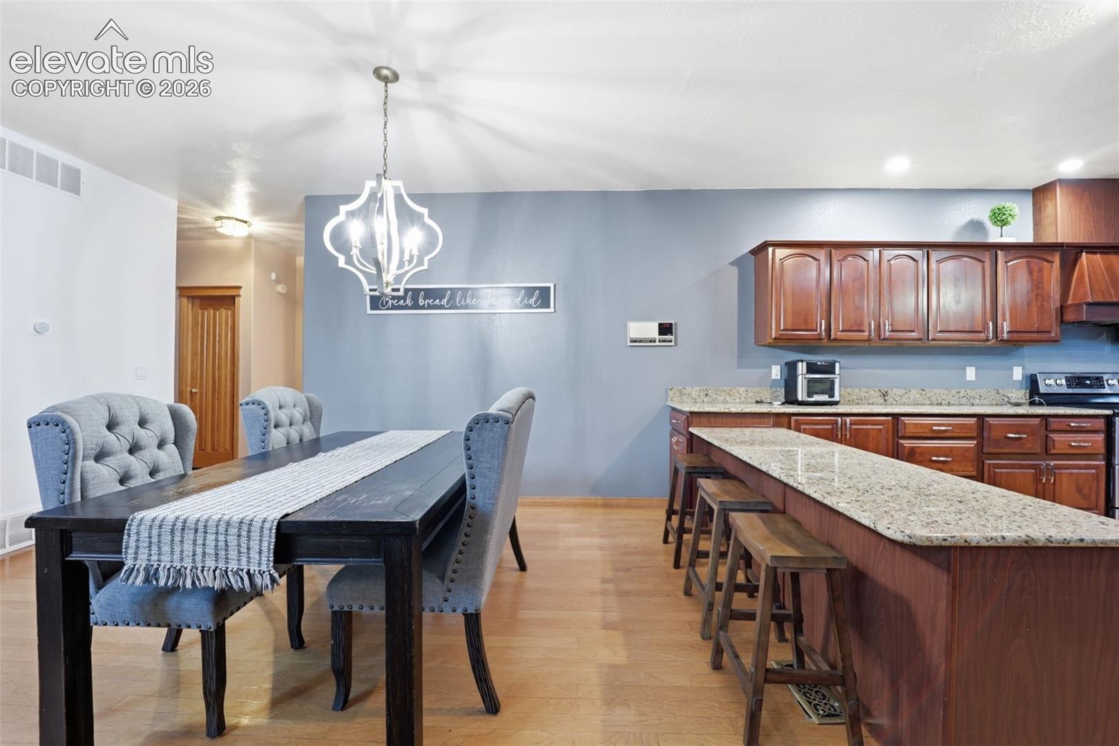 Wood-finish flooring throughout, with a decorative chandelier in the dining area