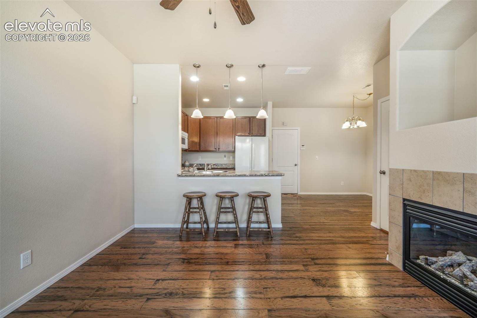 Warm wood-finish flooring complements the tiled fireplace with a built-in hearth